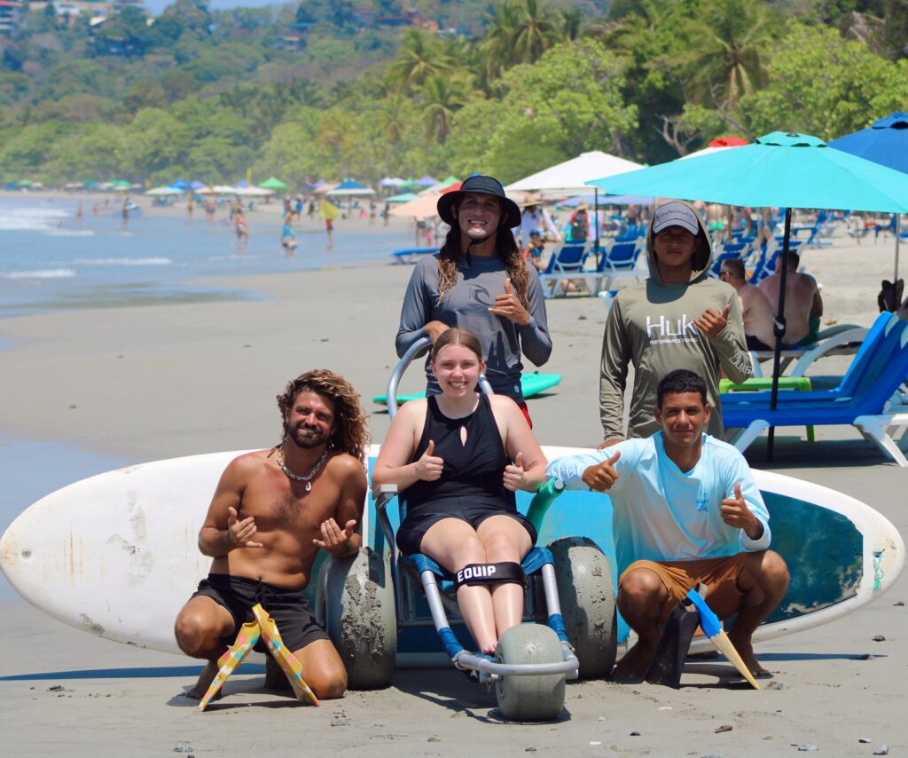 Mujer en silla anfibia con grupo de instructores de surf